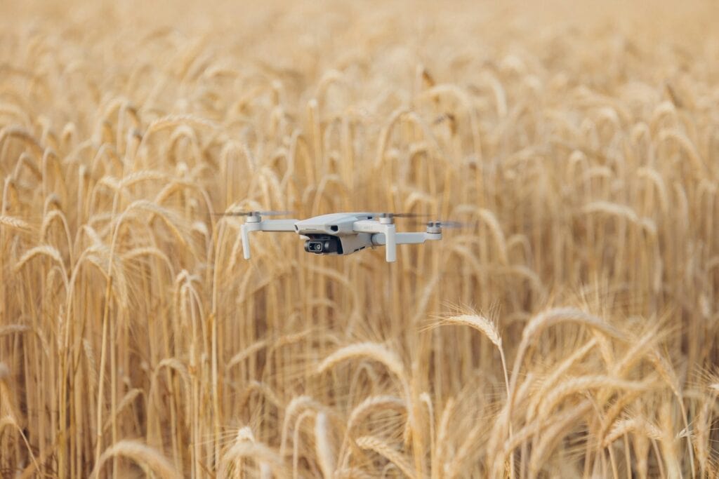 a precision drone flying over a field of wheat